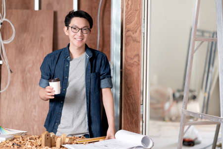 asian attractive glasses interior designer working at house site renovation construction progress...