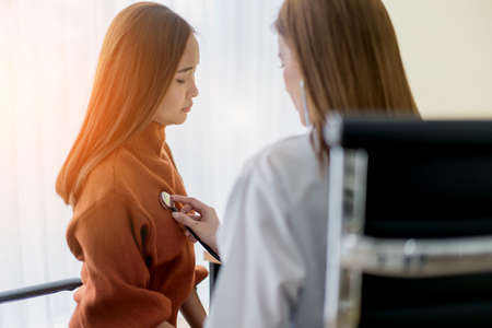 asian woman doctor Breast cancer Symptoms, risk factors, and treatment checking for patient in clinic officeの写真素材