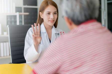 smart and attractive asian woman doctor explain and discuss with old asian man for consult clinic background health conceptの写真素材