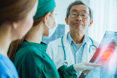 asian doctor team examine x-ray film of patient analysis to find bext solution for operation and...