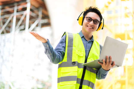 smart asian male professional civil engineer hand hold laptop site construction check with...