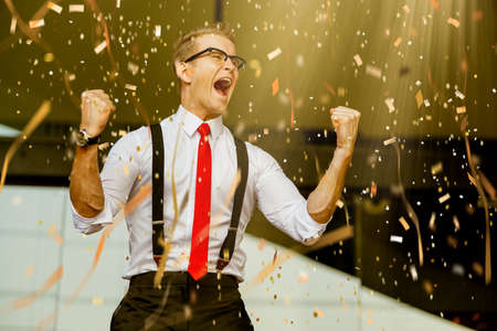 successful caucasian businessman white shirt and red tie hand up victory goal achieve with paper shoot confetti color toneの写真素材