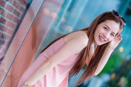 attractive asian beautiful female woman long hair casual summer cloth pink color dress smiling...