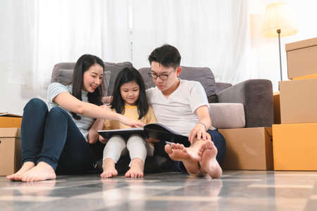 happiness asian family dad mom daughter sit relax enjoy watching tablet together with fun and exitedの写真素材