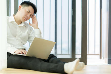 Serious asian male millennial businessman thinking cogitating about business issues. Frustrated...