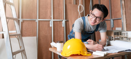 asian attractive glasses interior designer working at house site renovation construction progress...