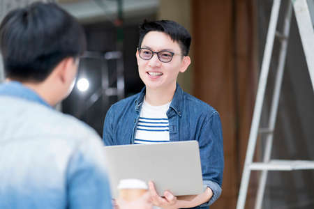 asian glasses male hand hold laptop casual meeting with partner in house renovation site construction background business, building, teamwork and people conceptの写真素材