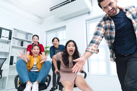 business leisure chair racing game competition Young cheerful asian business people dressed in...