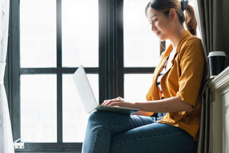 smart attractive asian female creative  woman happiness working with laptop casual dress sit next to...