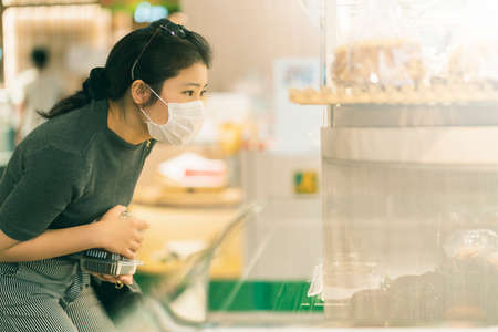 new normal after covid epidemic young smart asian female shopping new lifestyle in supermarket with...