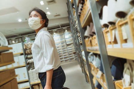 New normal lifestyle asian female white dress wear protecting mask shopping in department store after end of lockdown quarantine periodの写真素材