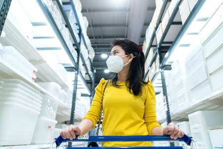 New normal lifestyle asian female yellow dress wear protecting mask shopping in department store after end of lockdown quarantine periodの写真素材