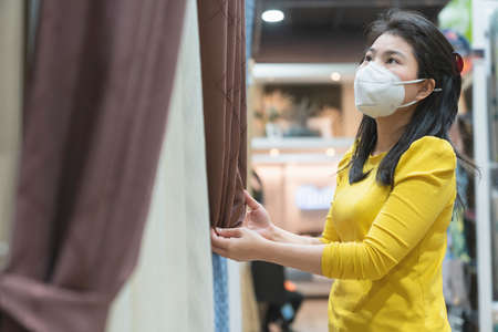 New normal lifestyle asian female yellow dress wear protecting mask shopping in department store after end of lockdown quarantine periodNew normal lifestyle asian female yellow dress wear protecting mask shopping in department store after end of lockdown quarantine periodの写真素材