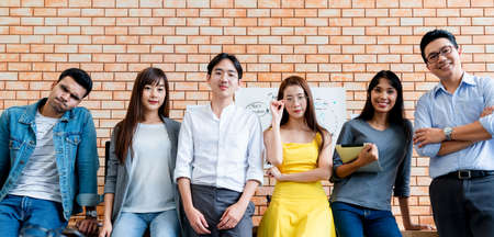 Group portrait of confident male and female creative designers standing together in modern design office backgroundの写真素材