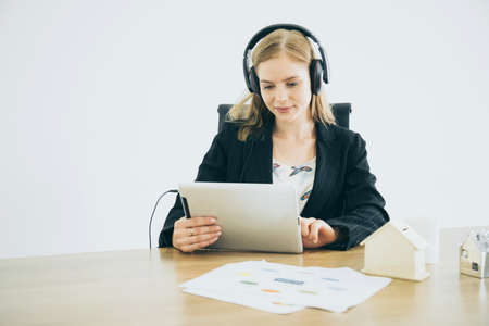 smart beauty caucasian operator contact client with tablet and headphone with happiness and joyfulの写真素材