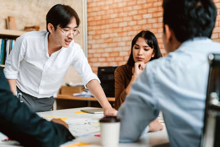 Happy colleagues discussing strategy plan during casual meeting at bright interior creative office design business ideas conceptの写真素材