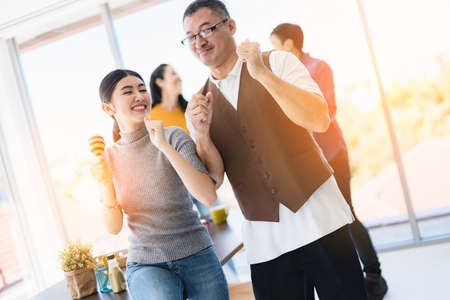 new year party in office business partner woman and men enjoy sing and dance together with happiness and joyful momentの写真素材