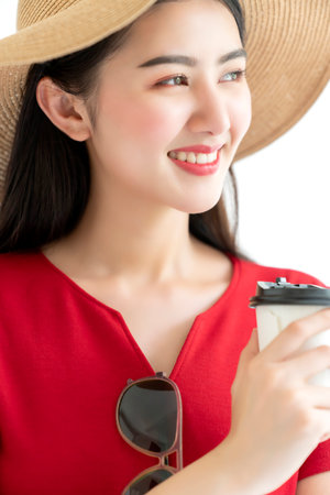 attractive beautiful asian woman red dress wear summer hat smile with happiness and joyful white backgroundの写真素材
