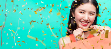 attractive beautiful asian woman red dress hand hold shopping bag big smile with happiness and joyful color backgroundの写真素材