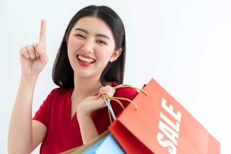 beautiful happiness asian teen woman red dress hand hold shopping bag summer sale concept white backgroundの写真素材