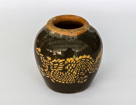 Glazed water jar with dragon patterns isolated in whiteの写真素材