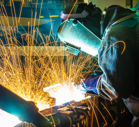 worker welder with protective mask welding metal