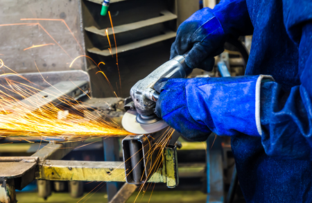 The worker grinding metal in manufacturing plantの写真素材