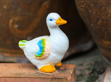 White duck statue on stone in gardenの写真素材