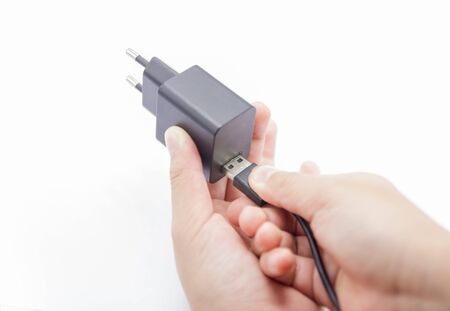 Connecting USB Cable to adapter charger for smartphone.