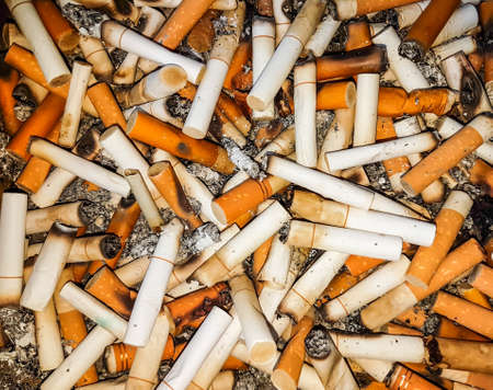 Cigarette butts in the ashtray, with sand.