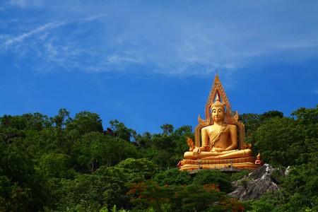 Big golden buddha on green mountain with clear sky,Rachaburi Thailand.の写真素材