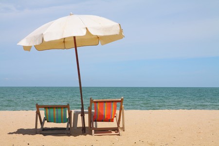 Deckchairs and parasol on the white sand beach facing cha-am beach, Thailandの写真素材