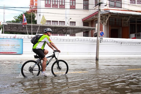 BANGKOK - october 29: Tourist riding bicycle through the largest flood  in 50 years in the capital on october 29, 2011 in Bangkok, Thailand.のeditorial素材
