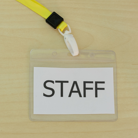 The staff card on wood background.の写真素材