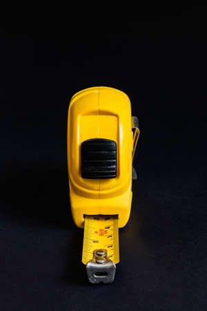 Yellow color tape measure, front view, isolated on black backgroundの写真素材
