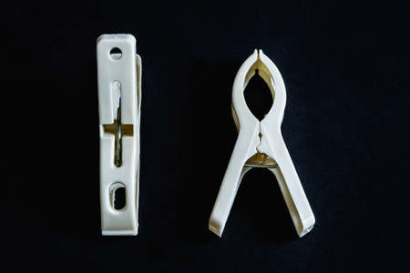 Two white plastic cloth clip isolated on black background