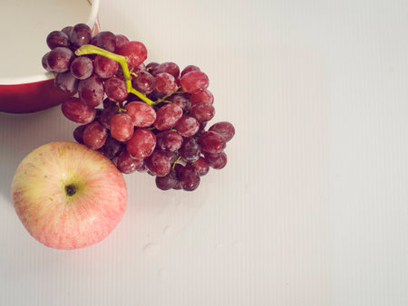 Grapes and apples lay top left corner. White backgroundの写真素材