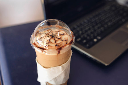Iced Coffee with laptop backgroundの写真素材