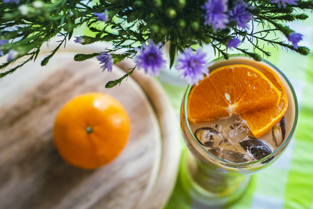 Glass of milk tea decorated with oranges, with orange fruit placed next to.の写真素材