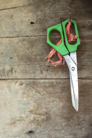Scissors hanging on the old wooden lid.の写真素材
