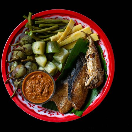 Fried mackerel with chili paste and boiled vegetables in a plateの写真素材