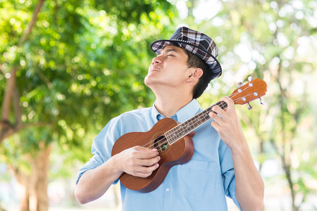 A man playing ukulele so happiness in park.の写真素材
