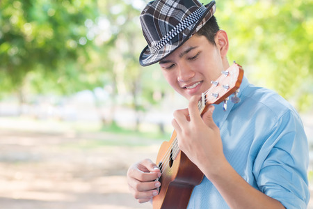 A man playing ukulele so happiness in park.の写真素材