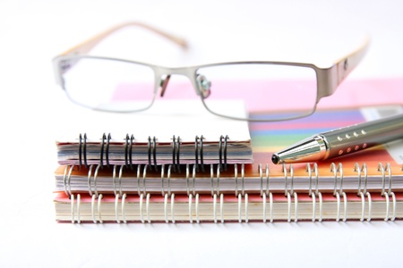 notebooks pen and glasses on white の写真素材