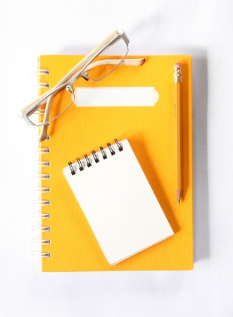 notebook glasses and yellow pencil on white の写真素材