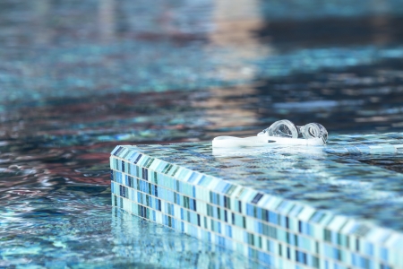 swimming goggles and turquoise swimming poolの写真素材