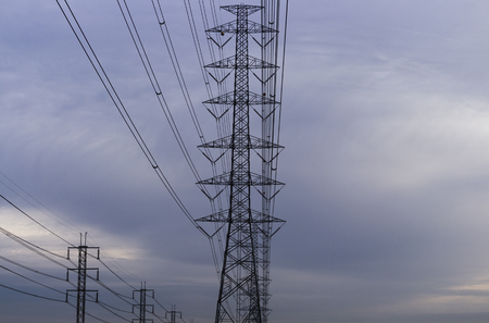 high voltage power lines and tower voltage above the head on a purple sky background in the morning.の写真素材