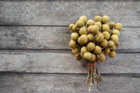 Top view on ripe longans on an old wooden background.の写真素材