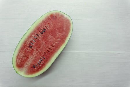Close Up over head of fresh watermelon fruit cut slice red Dissect isolated on wood table white...