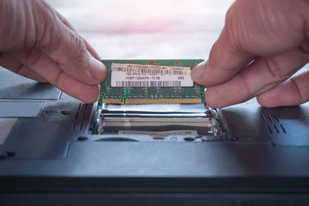 Repairman fixing and repair memory ram or setup hardware for the computer on laptop motherboard with...